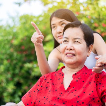 A caregiver helps an older woman.