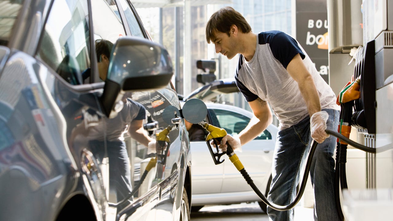 Man refueling vehicle at gas station