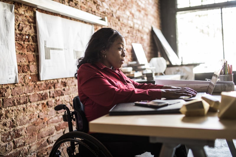 Businesswoman in wheelchair working at desk