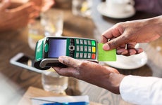 Waiter using credit card reader at restaurant table