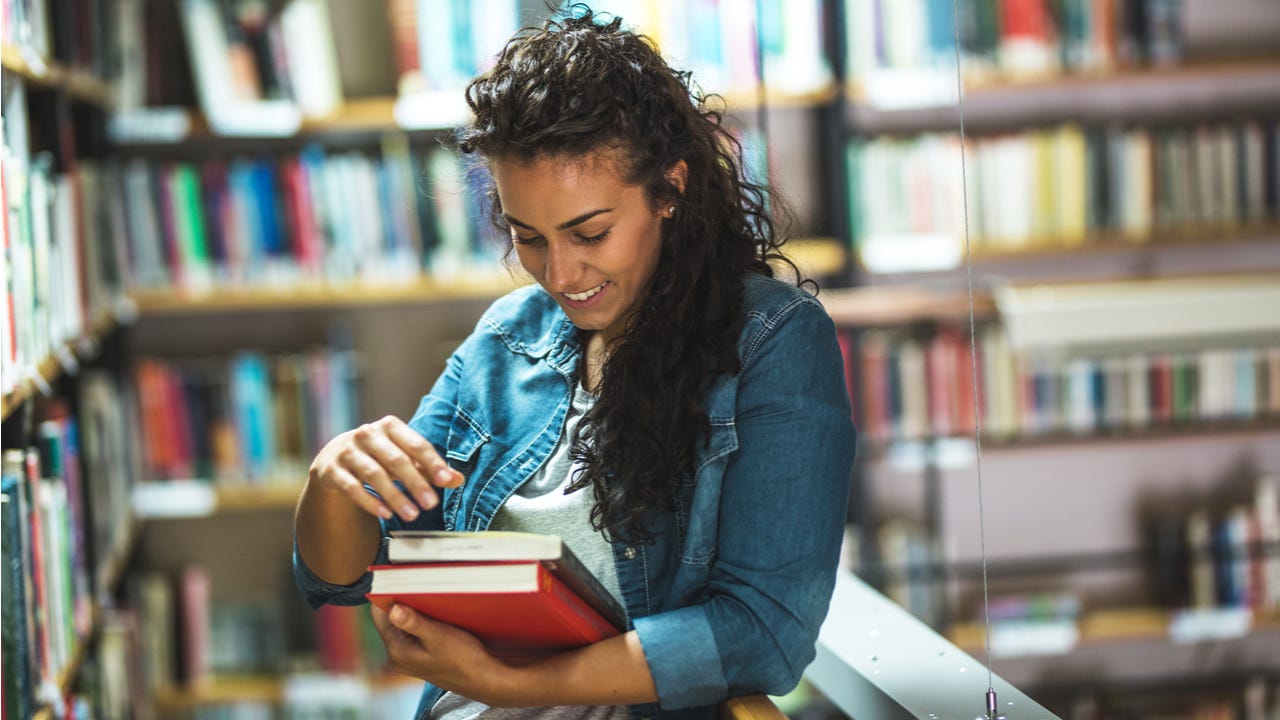 Woman checks out books in college library