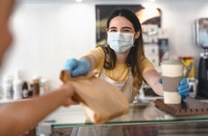Masked worker hands customer takeout
