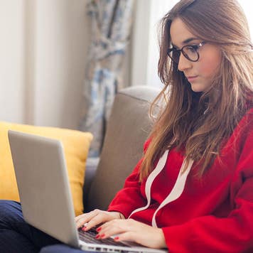 Woman using laptop on a sofa