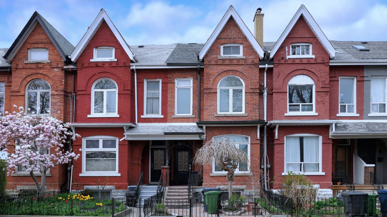 Urban residential street with row of attached old houses with gables