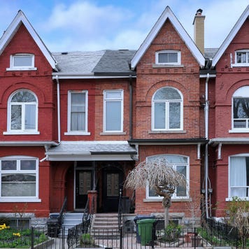 Urban residential street with row of attached old houses with gables