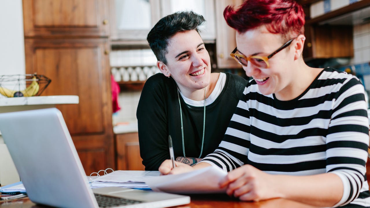 lesbian couple using laptop at home