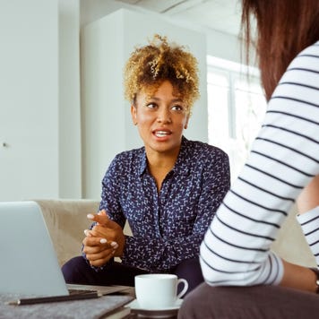 Mid adult businesswoman talking with customer