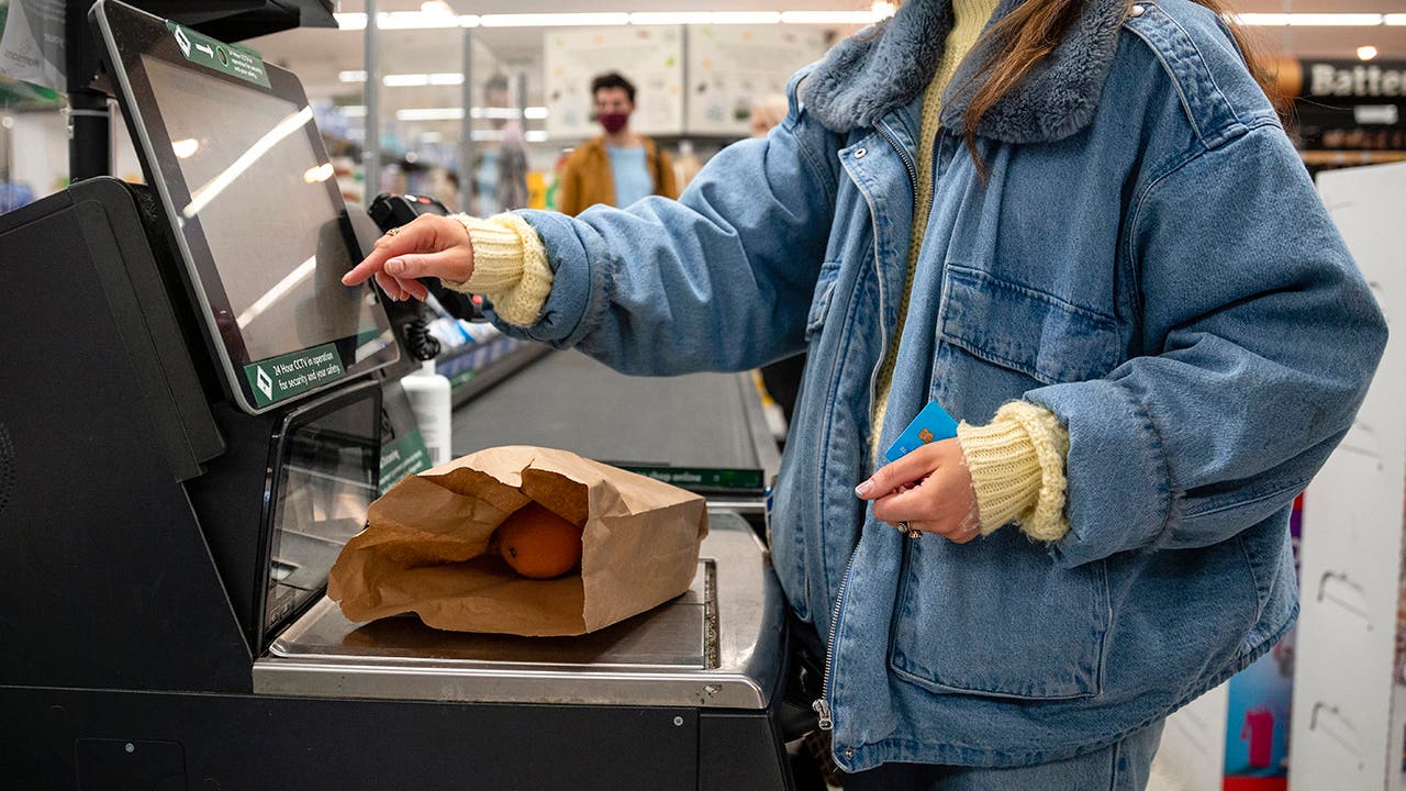 woman using self checkout at the grocery store