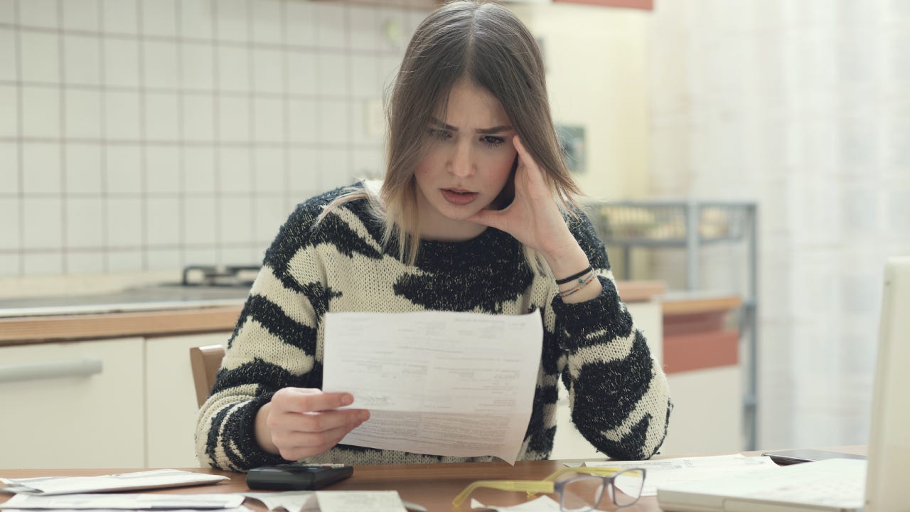 A worried woman going through her finances.