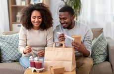 Black couple eating take out at home