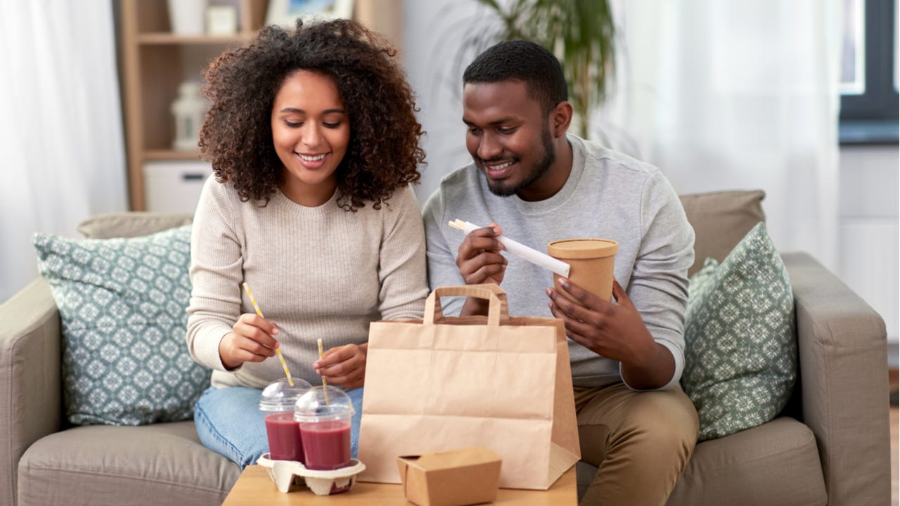 Black couple eating take out at home