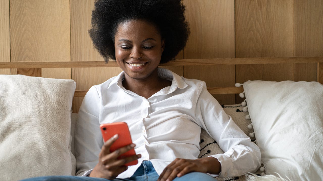 A young female researches on her phone.