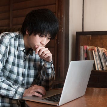 Man sat in a cafe using his computer