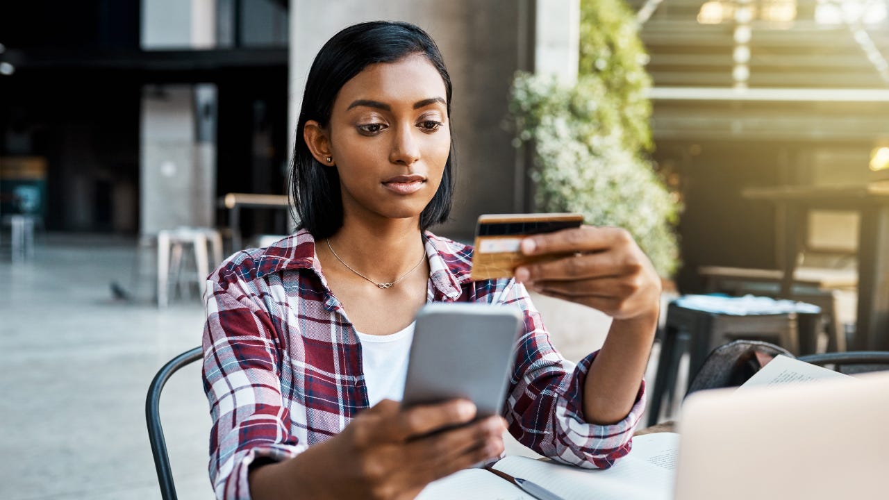 Young woman with credit card on her phone