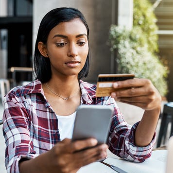 Young woman with credit card on her phone