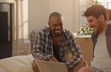 Two men in their new home looking at a laptop