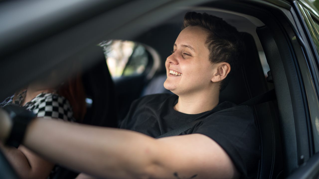 Driver young woman smiling inside the car