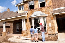 Builder meeting with woman and dauhter at new home under construction