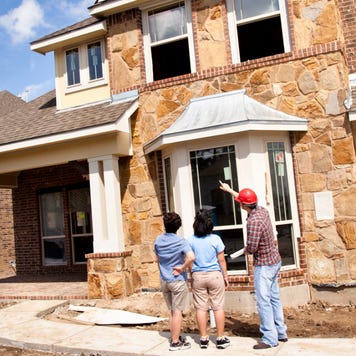 Builder meeting with woman and dauhter at new home under construction