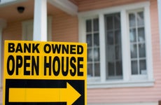 A closeup of a bank-owned open house sign