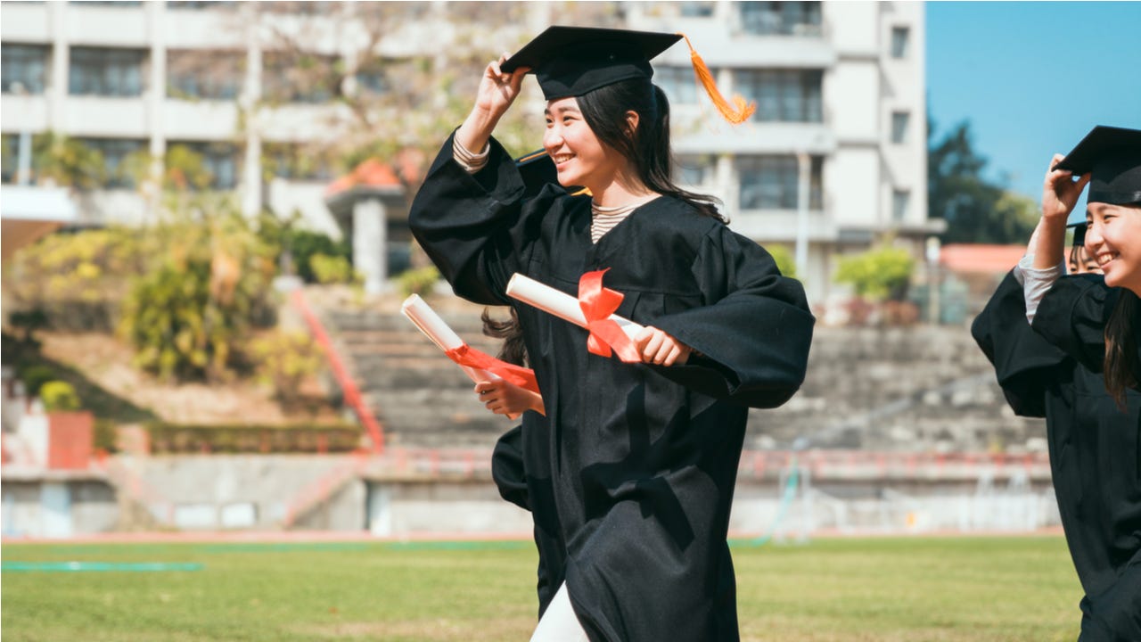 Woman carries diploma at graduation
