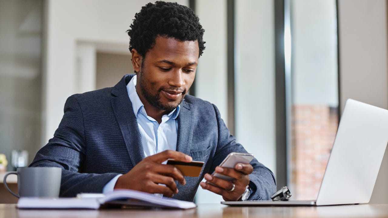 Business person holding credit card and phone