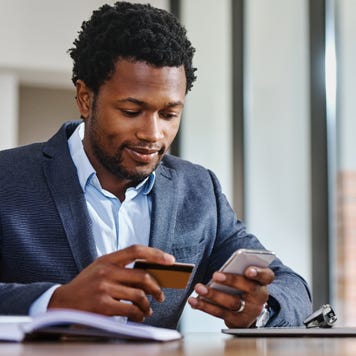 Business person holding credit card and phone