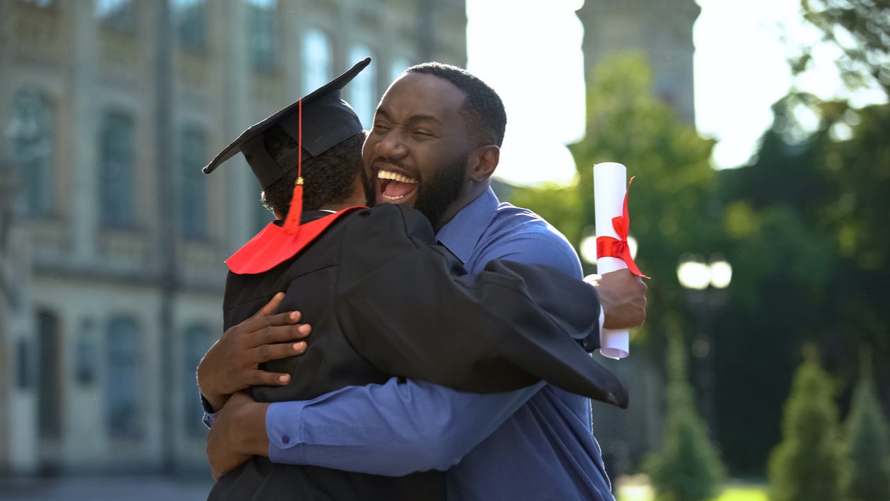 Father and son embrace at college graduation