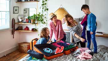 Lesbian couple packing suitcases for holiday with children