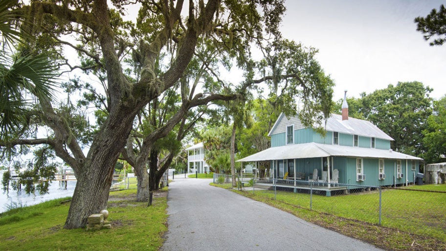 A home on the Florida coast with Spanish moss hanging off the tree branches.