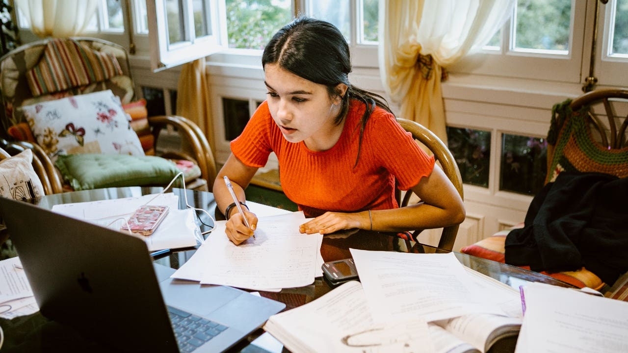 High school student works on homework at a desk