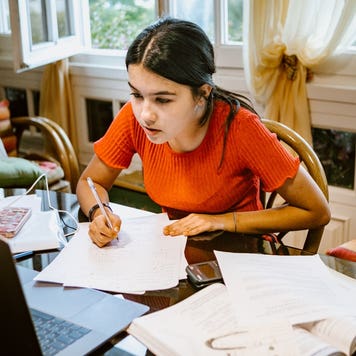 High school student works on homework at a desk