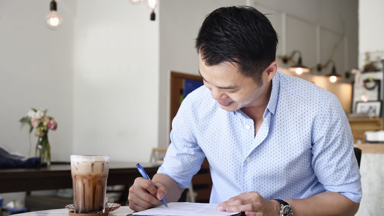 Business man reviewing paperwork in a cafe