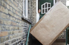 Woman looking at package at entrance of house