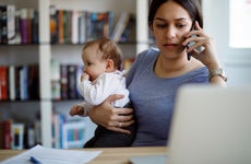 Worried mother holds baby while on the phone