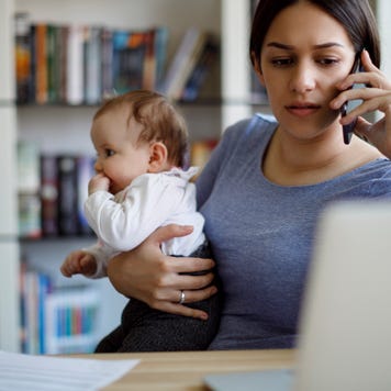 Worried mother holds baby while on the phone