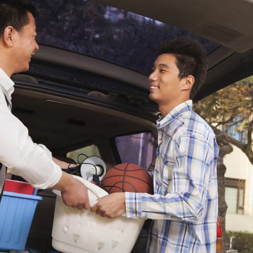 Father and son unpack from the back of a car