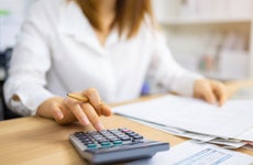 Woman using a calculator and examining financial documents