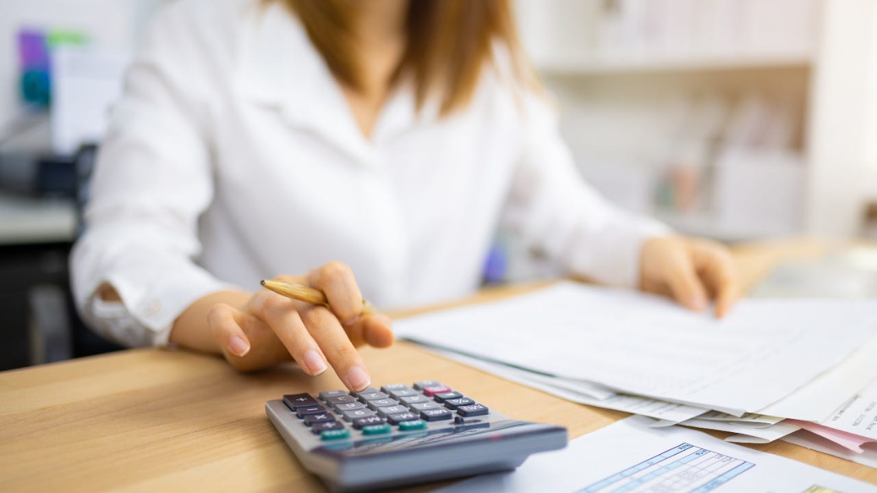 Woman using a calculator and examining financial documents