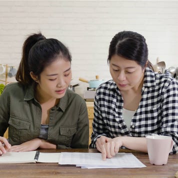 Two women go over paperwork in the kitchen