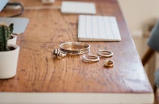 Woman's silver jewellery on a desk next to a computer