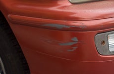 Red bumper car scratched with deep damage to the paint