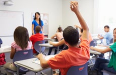 High school student raises hand in class