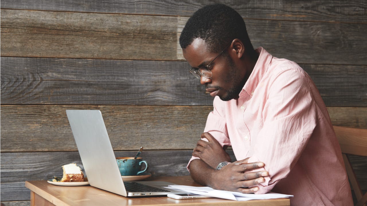 Man works on a laptop at a cafe