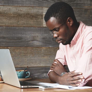 Man works on a laptop at a cafe