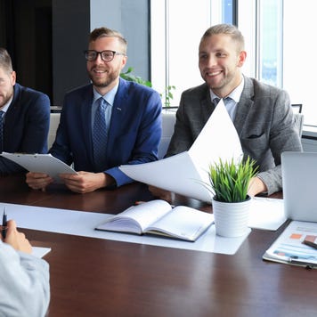 Panel of lawyers sit at a table