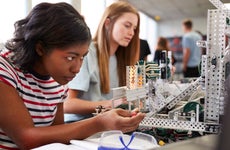 Young woman works on a project in a robotics class