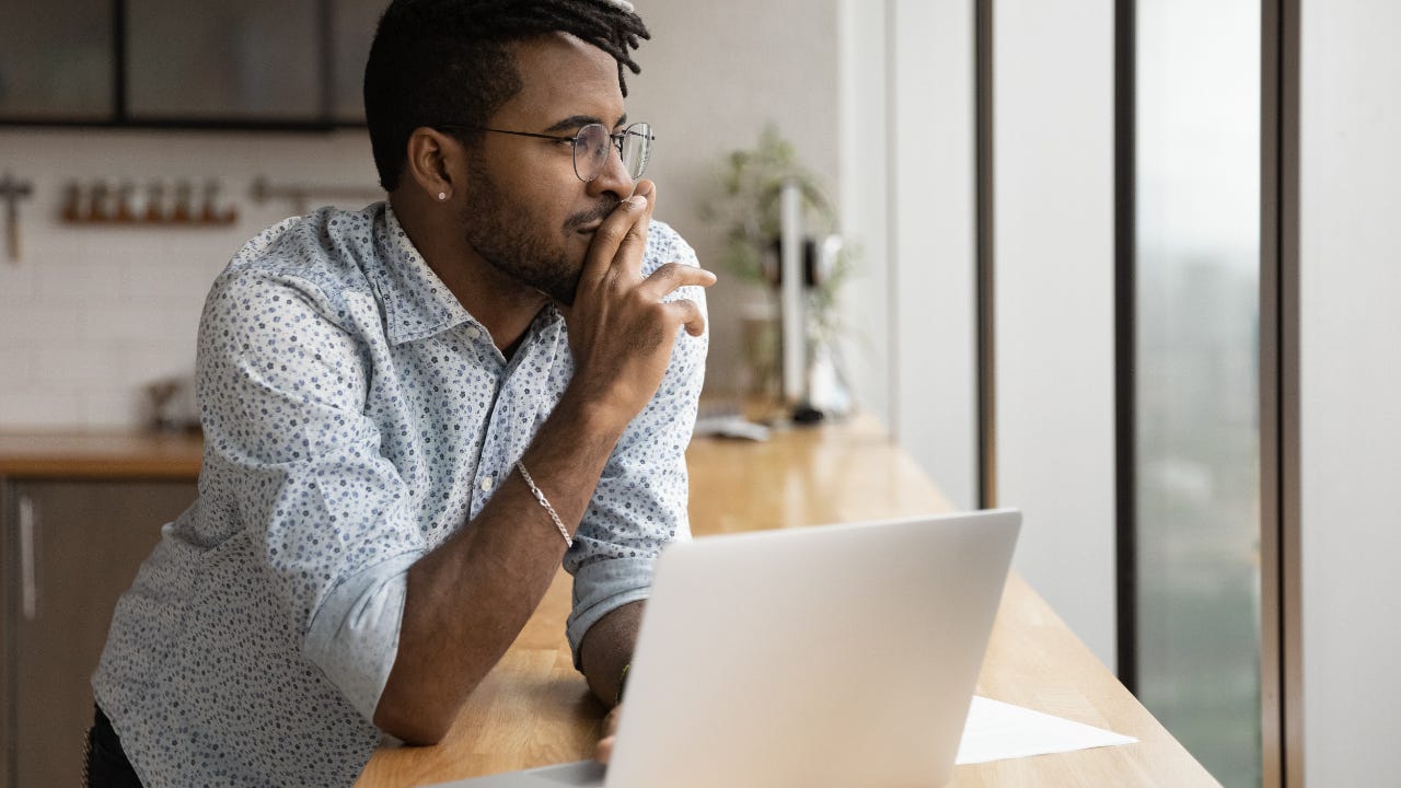 Man sitting at counter with laptop.