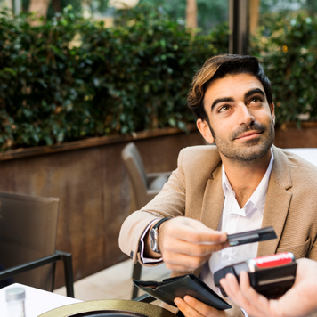 white man handing card to pay