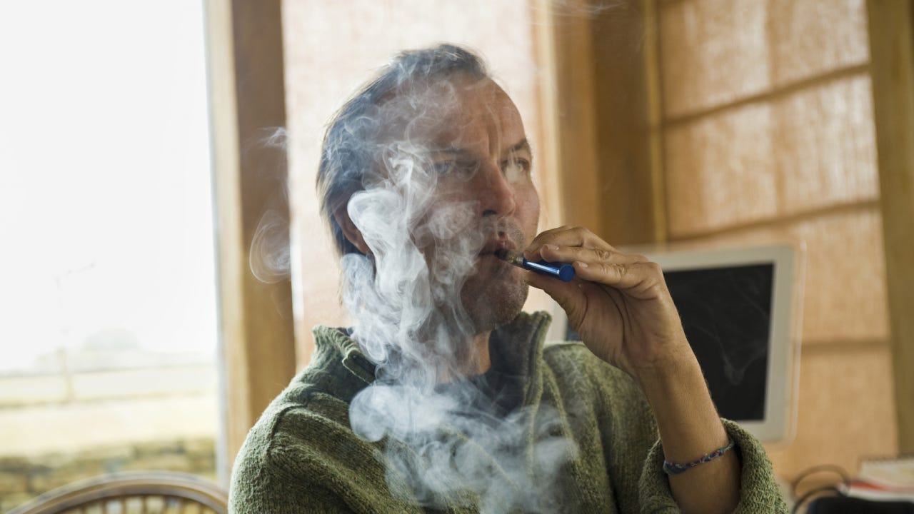 A man using an electronic cigarette, vaping.